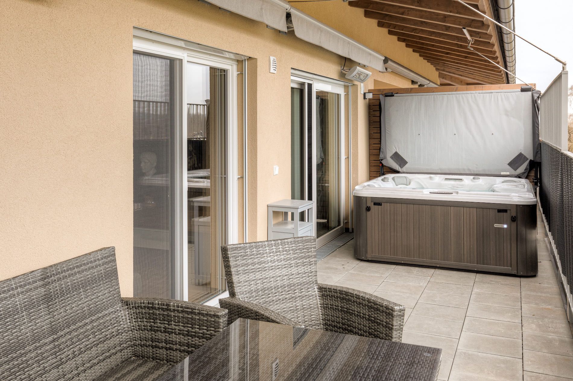 Terrasse der Penthouse-Wohnung mit Whirlpool und Gartenmöbeln