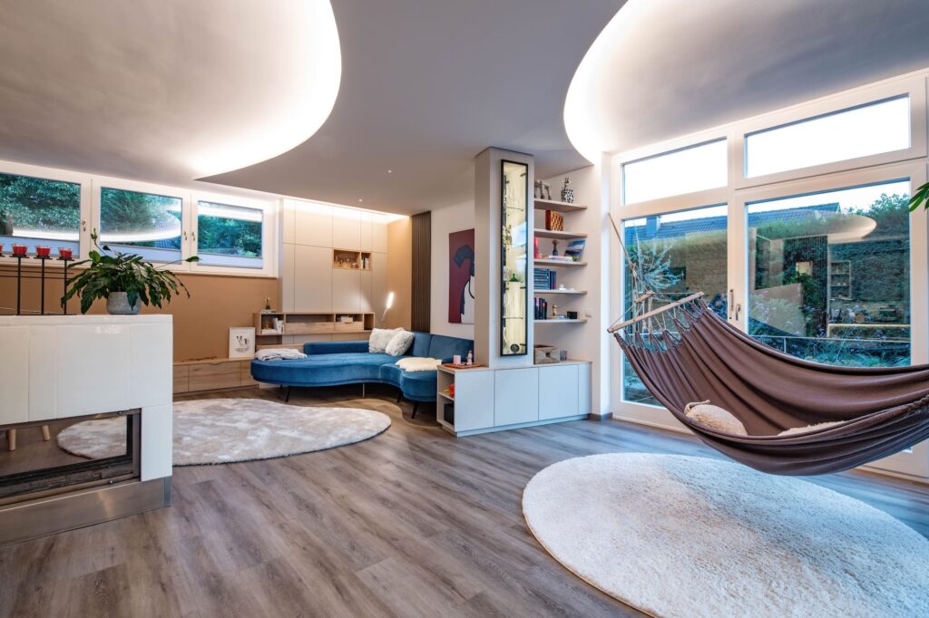 Großzügiges Wohnzimmer mit abgestimmten Lichtkonzept, Kamin und Hängematte