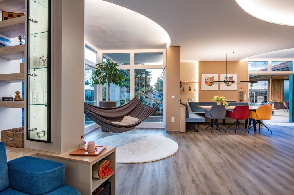 Großzügiger Wohnzimmer, Ess- und Wohnbereich mit abgestimmten Lichtkonzept und Chillecke mit Hängematte