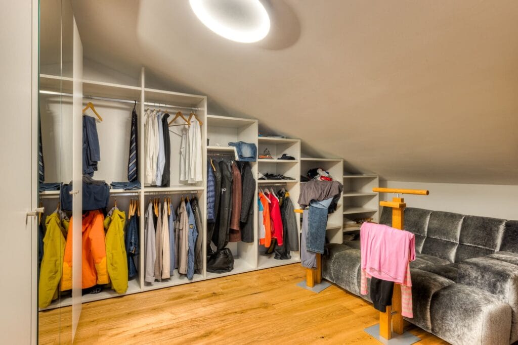 Ankleidezimmer in einer Dachgeschosswohnung mit offenen Wandschränken
