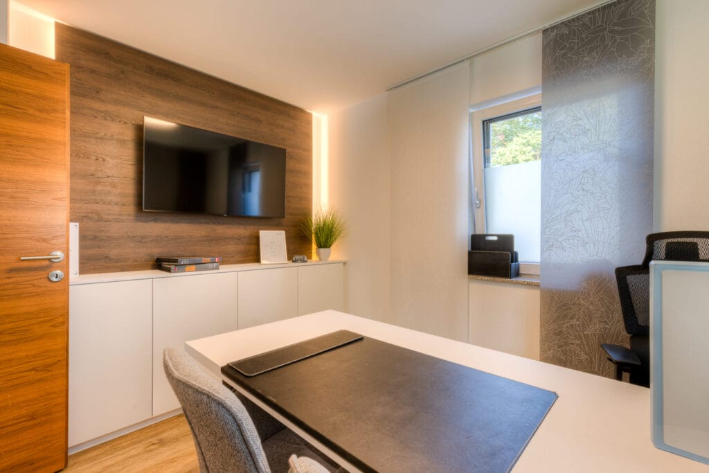 Homeoffice - Büro mit Besprechungstisch und TV-Panel in Holzoptik