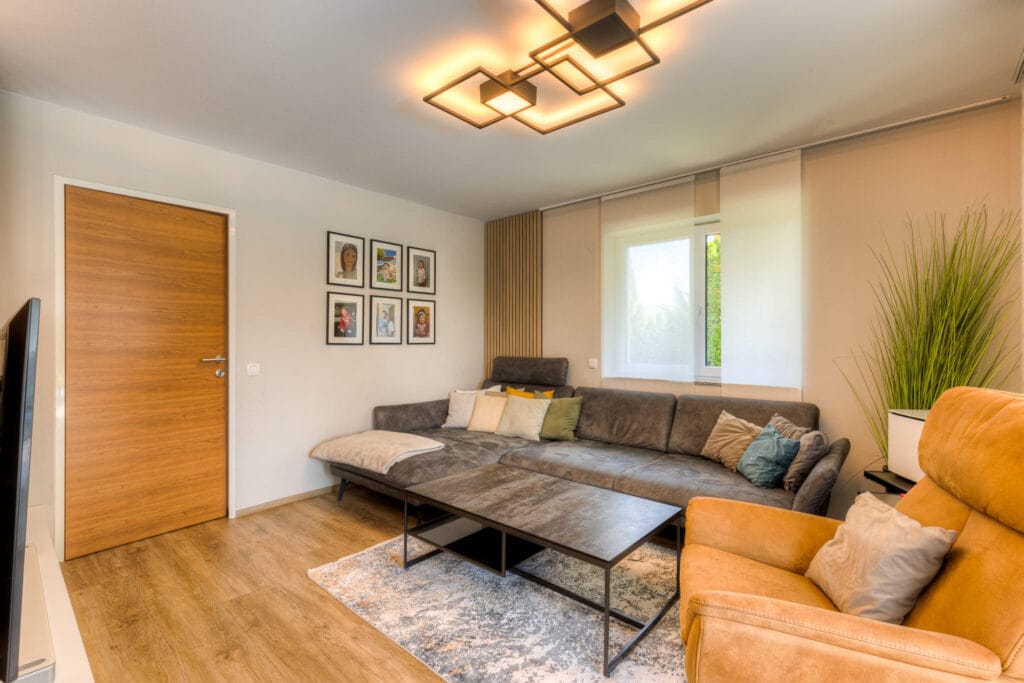 Wohnzimmer mit Holzfußboden, gemütlichen Couchmöbeln und Stimmungslicht